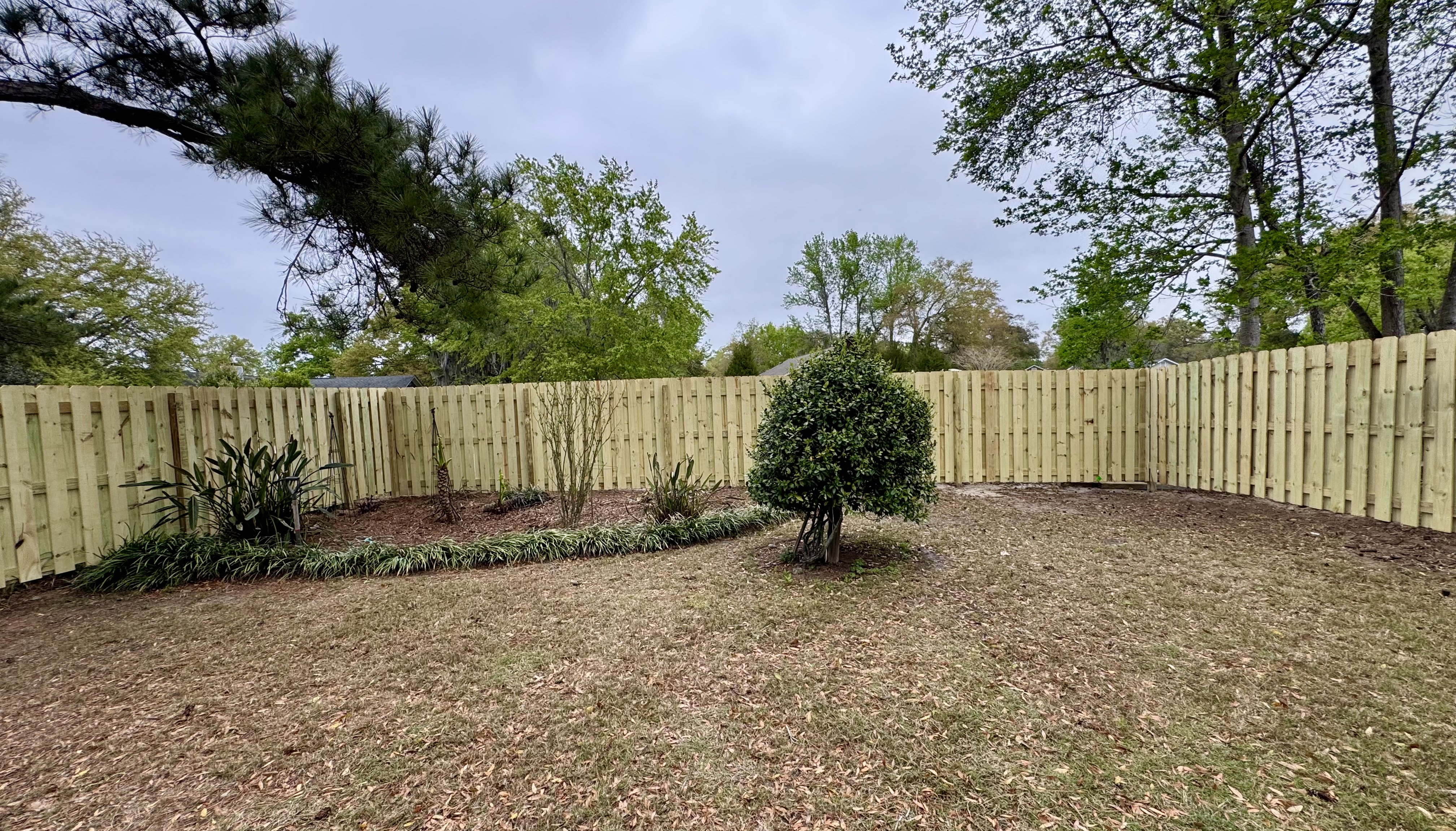 Completed wood privacy fence installed around a Camden County, Georgia backyard by Lynn’s Fencing LLC